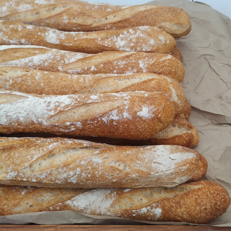Two golden French baguettes resting on a linen cloth