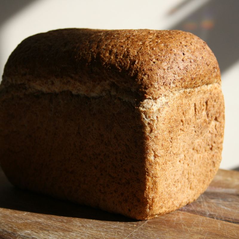 A sliced wholemeal tin loaf on a wooden board