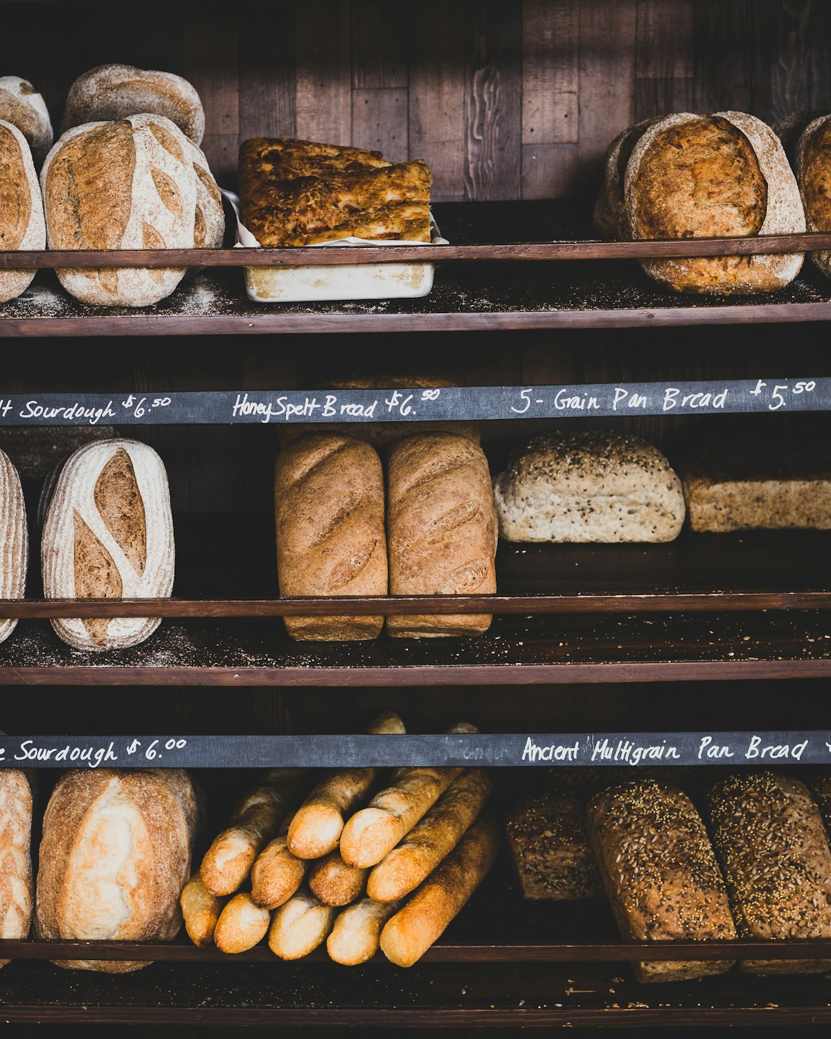 Bakers shaping dough on a flour-dusted wooden bench